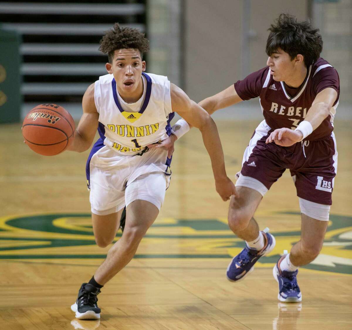 Midland High's D'Marion White brings the ball down court as Legacy High's Nate Suttle defends 01/07/2022 at the Chaparral Center. Tim Fischer/Reporter-Telegram