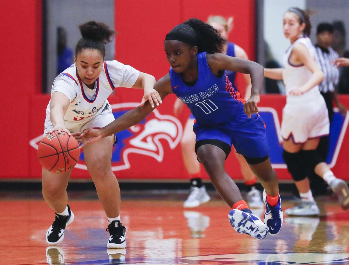 Grand Oaks point guard Bree Riley (11) tips the ball away from Oak Ridge point guard Taylor Jones (30) during the first quarter of a District 13-6A high school girls basketball basketball game at Oak Ridge High School, Friday, Jan. 7, 2022.