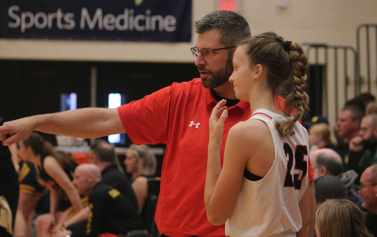Reed City girls basketball coach Tim Beilfuss (left) points something out to Kyleigh Weck during recent action.