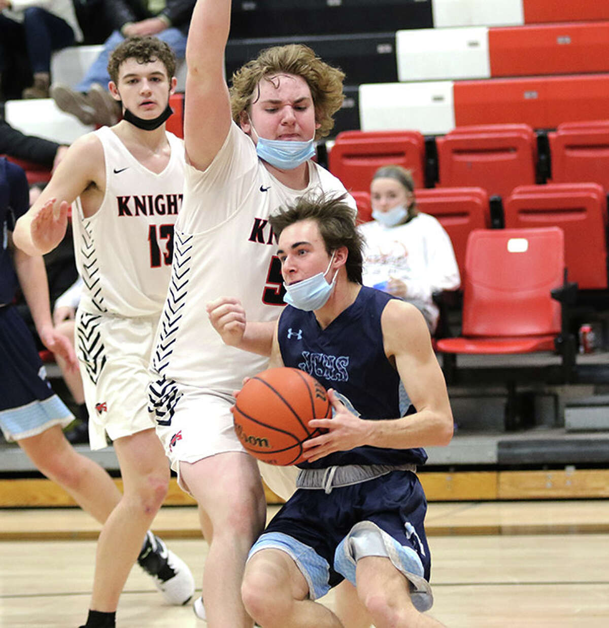 Jersey's Drake Goetten (right) drives baseline and looks for options against Triad's 6-7 Lane Mahnesmith in the second half Friday night at Rich Mason Gym in Troy.