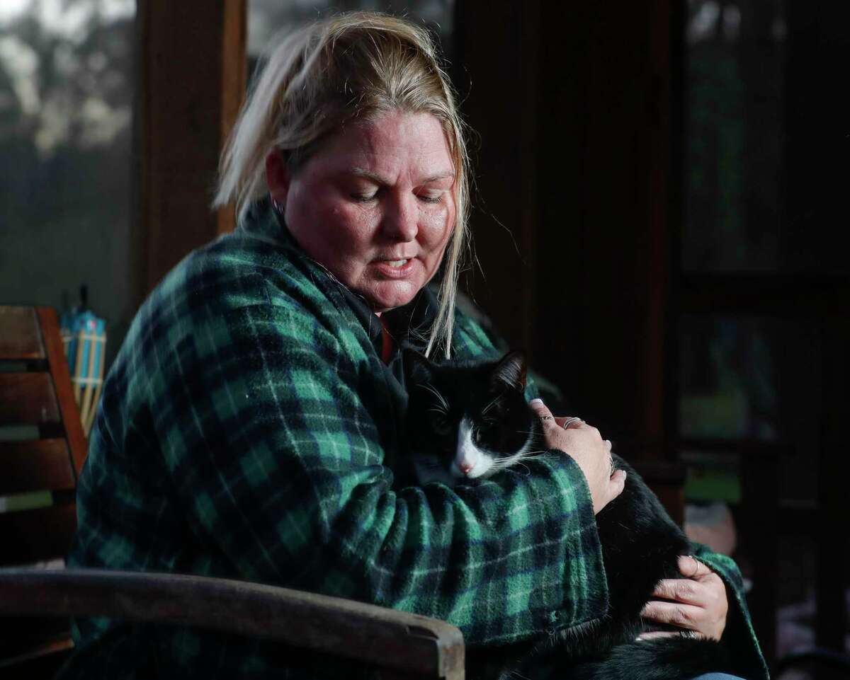Nicky Flowers comforts her one-year-old cat, Tom, at her home, Friday, Jan. 7, 2022, in Splendora. Flowers, who owns multiple rescue cats, has an ongoing felony animal cruelty case against a neighbor after two cats were shot and killed, while Tom was left blind in one eye by a bullet that still remains in his skull.