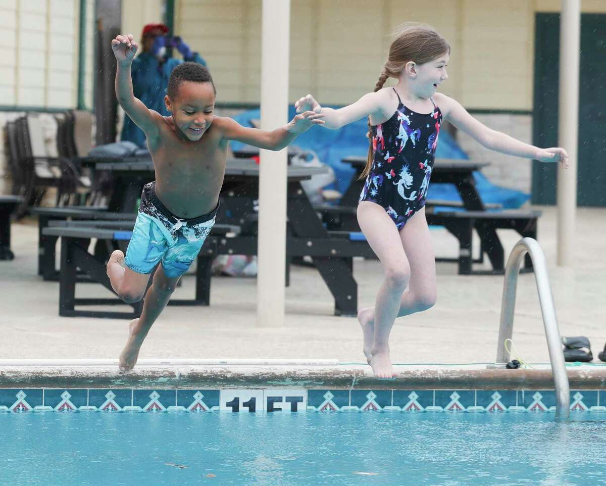 John Row and Abigail Shiver leap into the pool during the annual Polar Bear Plunge at Mary Pat Case Pool, Saturday, Jan. 8, 2022, in Shenandoah.