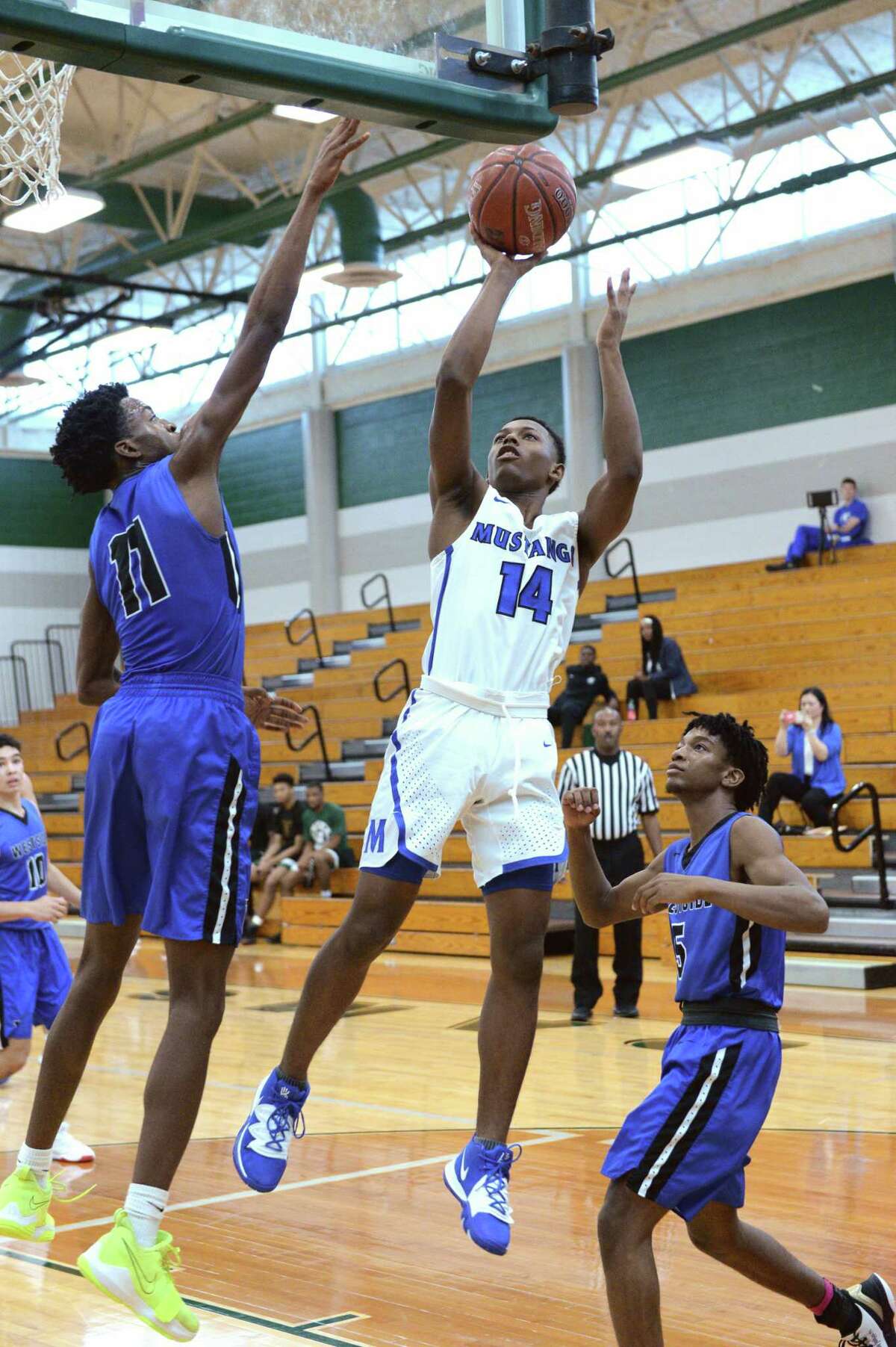 Angel Sonnier (14) of Taylor attempts a shot past Chinonso Ezekwesili (11) of Westside during the 2019 Katy Classic Basketball Tournament at Mayde Creek Hight School. Sonnier has played the last seasons at Mayde Creek, leading the Rams to an 18-6 start this year.