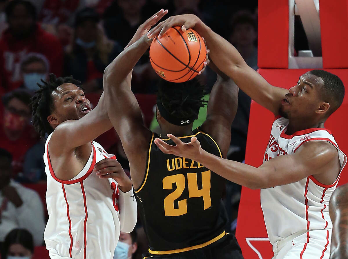 Houston center Josh Carlton (25) and forward Fabian White Jr. (35) defend a shot by Wichita State forward Morris Udeze (24), resulting in a blocked shot and a jump ball, during the second half on an NCAA basketball game Saturday, Jan. 8, 2022, in Houston.