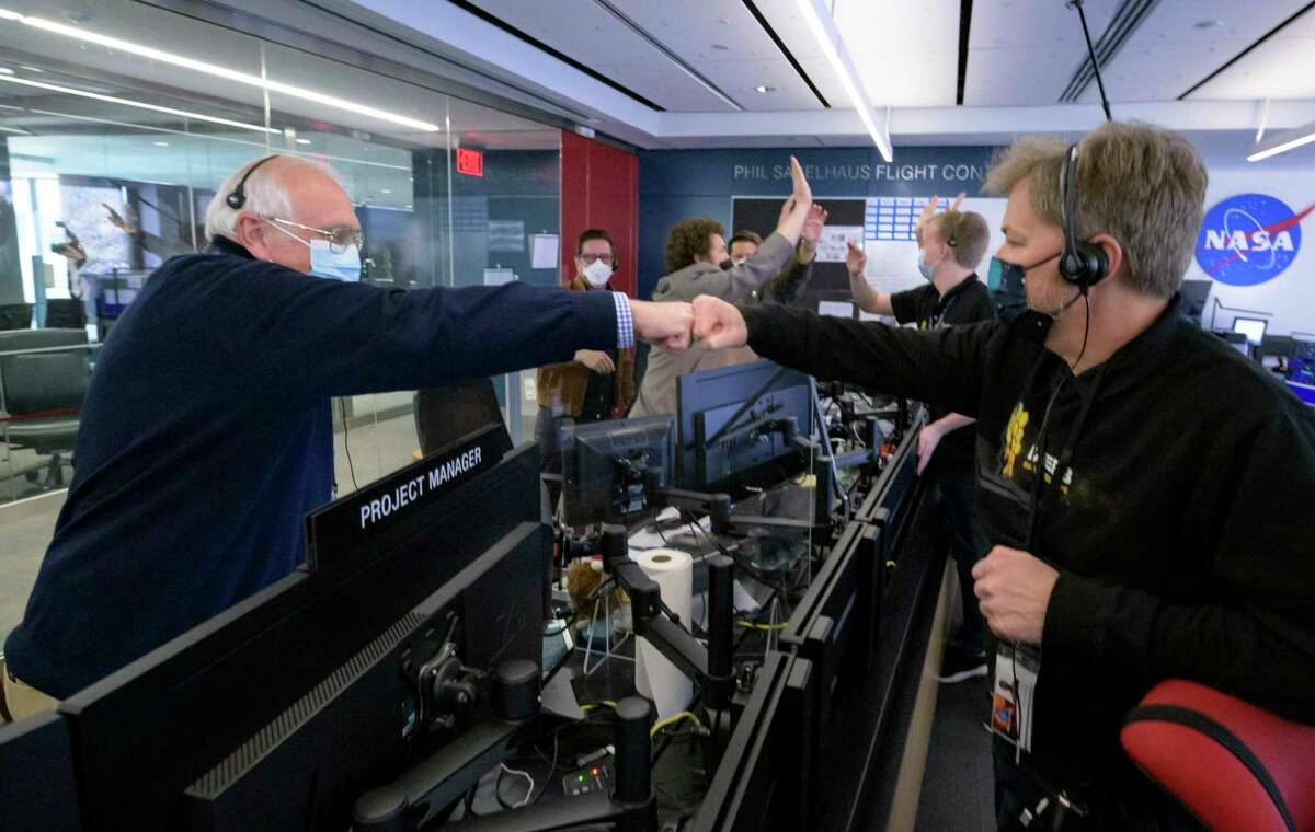 NASA James Webb Space Telescope Project Manager Bill Ochs, left, NASA James Webb Space Telescope Commissioning Manager John Durning, right and others from the operations team celebrate, Saturday, Jan. 8, 2022, at the Space Telescope Science Institute in Baltimore, after confirming that the observatory's final primary mirror wing successfully extended and locked into place. (Bill Ingalls/NASA via AP)