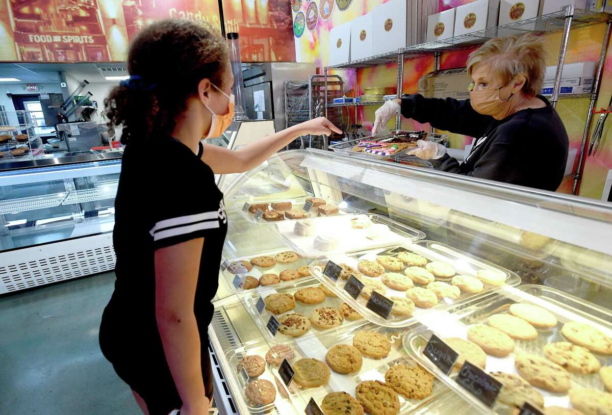 Co-owner Darlene Hanna helps Cache Buehrle select a cookie at CharLee and the Cookie Factory, which will host a grand opening celebration Saturday. Nashville country singer Glen Templeton - co-owner and Hanna's son Brian Dunigan's best friend - will be on hand to join in the opening event before performing a show in Silsbee later that night. Photo made Wednesday, January 5, 2022 Kim Brent/The Enterprise