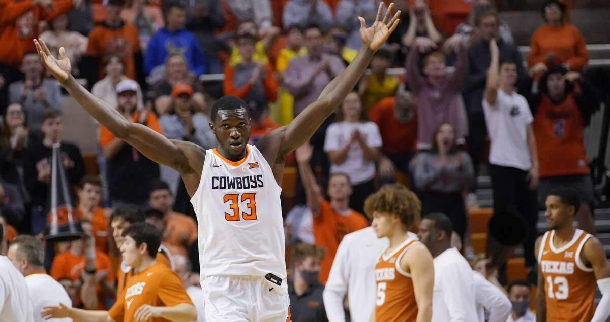 Oklahoma State forward Moussa Cisse (33) gestures to fans in the second half of an NCAA college basketball game against Texas, Saturday, Jan. 8, 2022, in Stillwater, Okla. (AP Photo/Sue Ogrocki)
