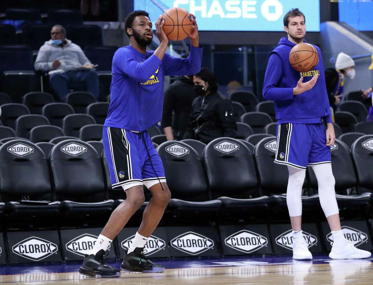 Golden State Warriors' Andrew Wiggins and Nemanja Bjelica warm up before playing Denver Nuggets during NBA game at Chase Center in San Francisco, Calif., on Tuesday, December 28, 2021.