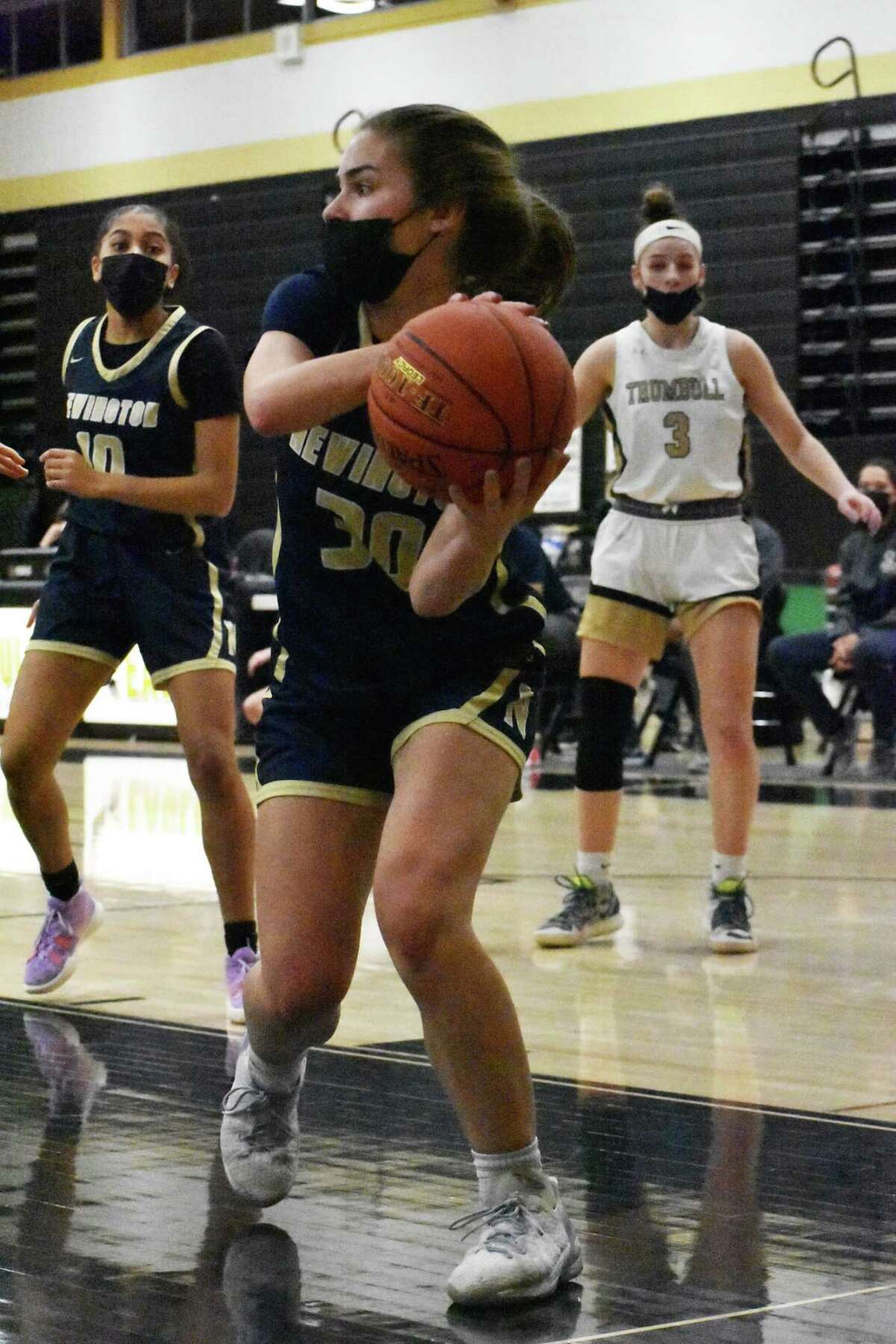Newington's Marlie Zocco saves the ball from going out of bounds during a girls basketball game between Trumbull and Newington at Trumbull High, Trumbull on Saturday, Jan. 8, 2022.