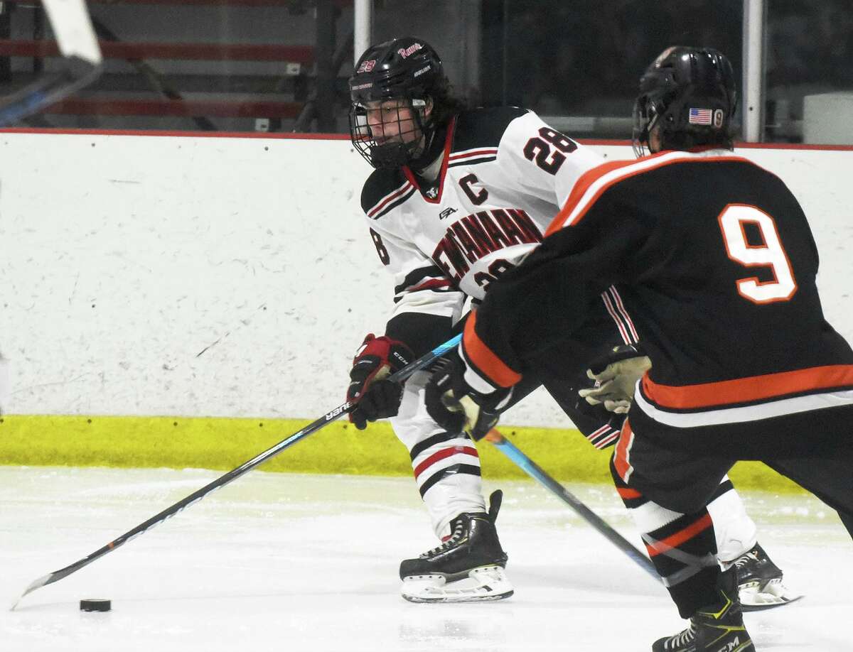 New Canaan's Michael Rayher (28) controls the puck during the Rams' boys ice hockey game against Ridgefield at the Darien Ice House on Saturday, Jan. 8, 2022.