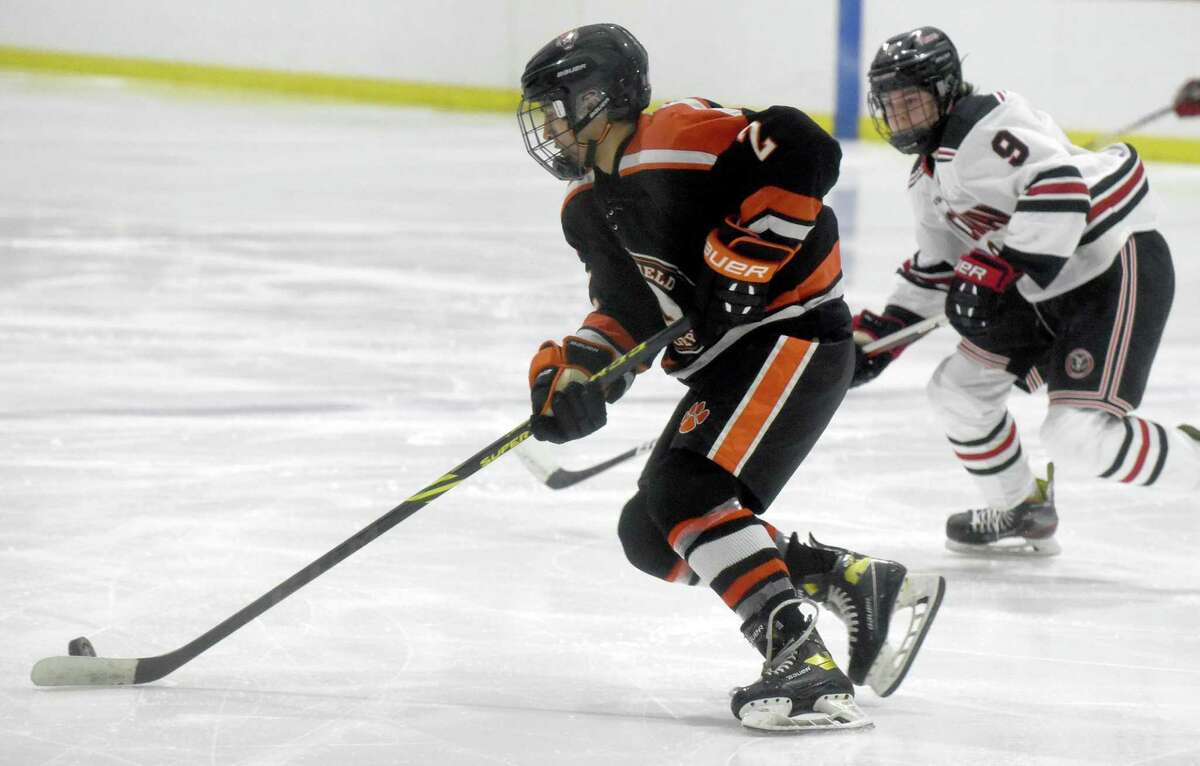 Ridgefield's Aiden Chang (2) skates with the puck as New Canaan's Byrne Matthes (9) skates back to defend during a boys ice hockey game at the Darien Ice House oin Saturday, Jan. 8, 2022.
