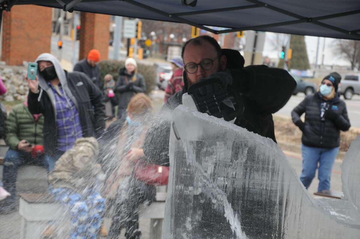Spectators watch David Van Camp, owner of Ice Visions from Kirkwood, Missouri, carve ice at the Eagle Fest Saturday in Alton. This year's event featured additional activities.