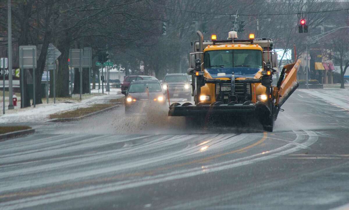 A plow truck clears the surface of Wolf Road on Sunday, Jan. 9, 2022, in Albany, N.Y.
