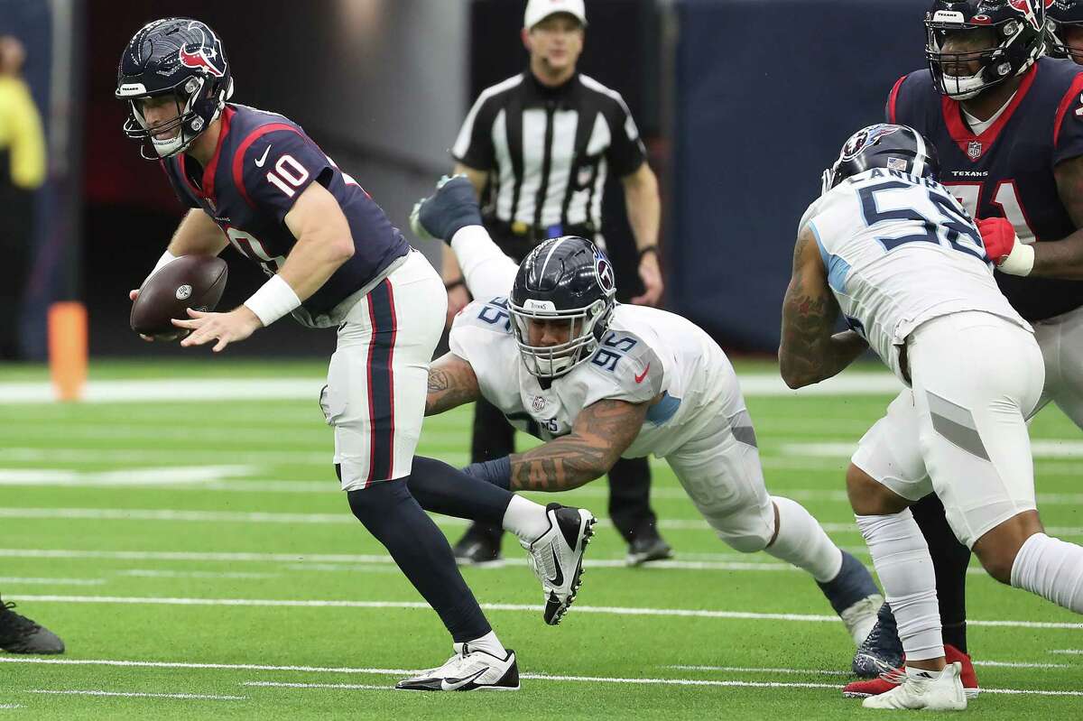 Houston Texans quarterback Davis Mills (10) is caught by Tennessee Titans defensive tackle Kyle Peko (95) as he tries to run out of the pocket during the first quarter of an NFL football game Sunday, Jan. 9, 2022 in Houston.