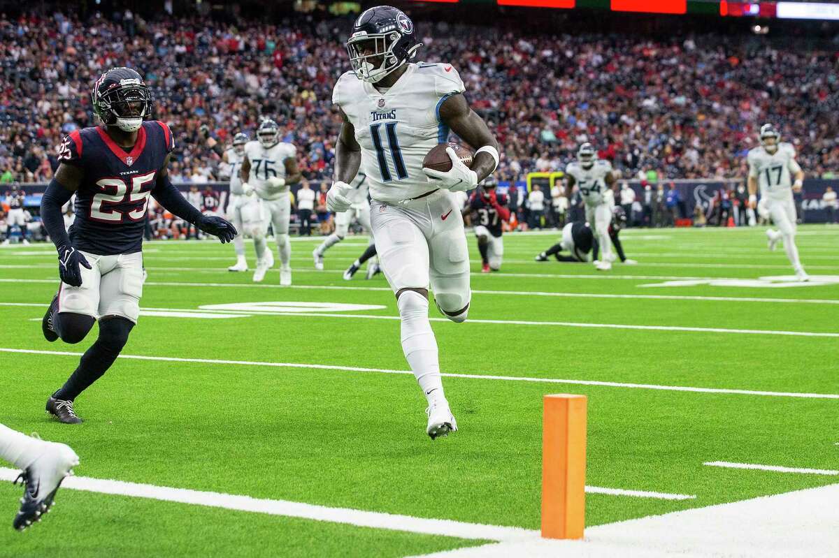 Tennessee Titans wide receiver A.J. Brown (11) runs past Houston Texans cornerback Desmond King II (25) for a 14-yard touchdown reception during the second quarter of an NFL football game Sunday, Jan. 9, 2022 in Houston.