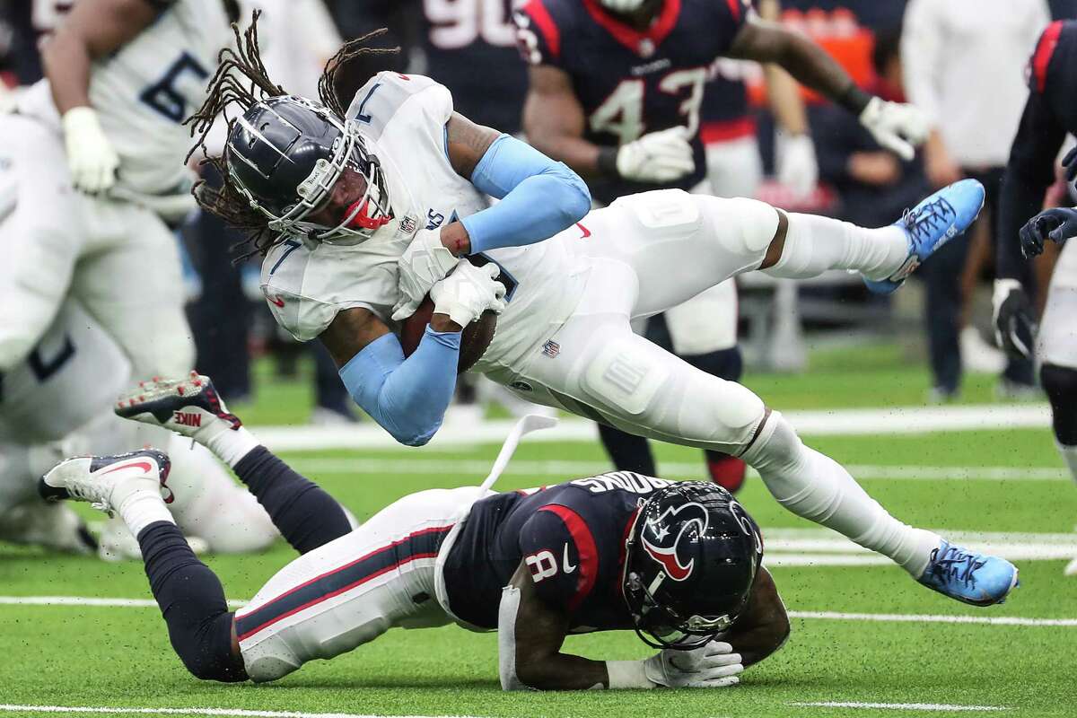 Tennessee Titans running back D'onta Foreman (7) is tripped up by Houston Texans free safety Terrence Brooks (8) during the second quarter of an NFL football game Sunday, Jan. 9, 2022 in Houston.