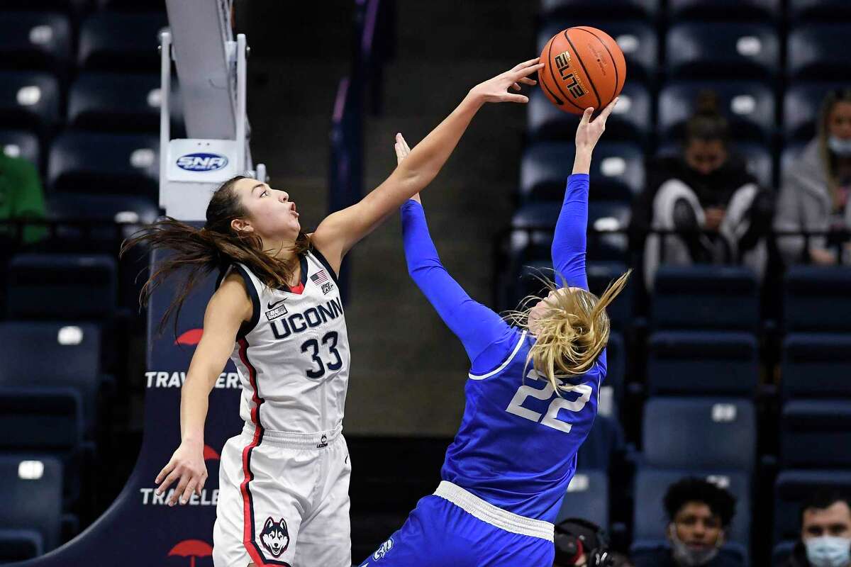 UConn’s Caroline Ducharme, left, blocks a shot by Creighton’s Carly Bachelor in the second half on Sunday.
