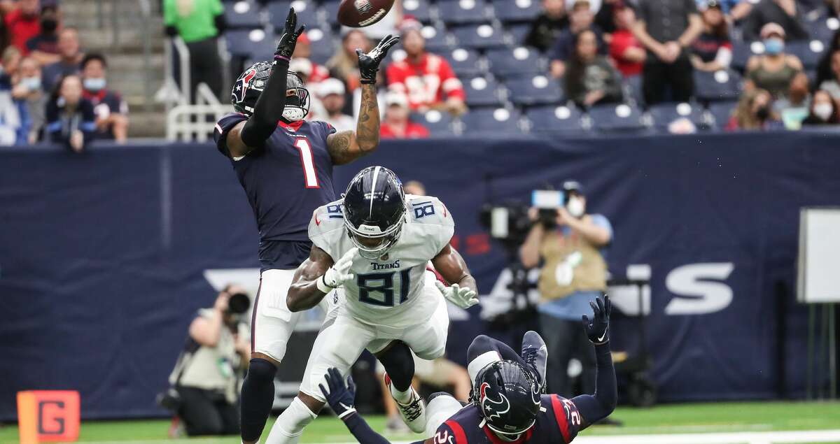 Houston Texans free safety Lonnie Johnson (1) leaps over Tennessee Titans wide receiver Racey McMath (81) and Texans free safety Eric Murray (23) to intercept a pass during the second quarter of an NFL football game Sunday, Jan. 9, 2022 in Houston. The interception was nullified when Murray was called for pass interference on the play.