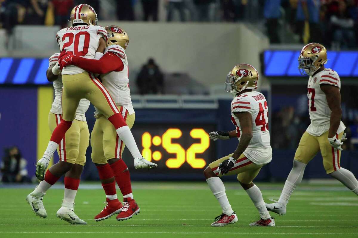 Cornerback Ambry Thomas celebrates with teammates after his interception in overtime, the first of his career, beat the Rams and sent the 49ers to the playoffs.