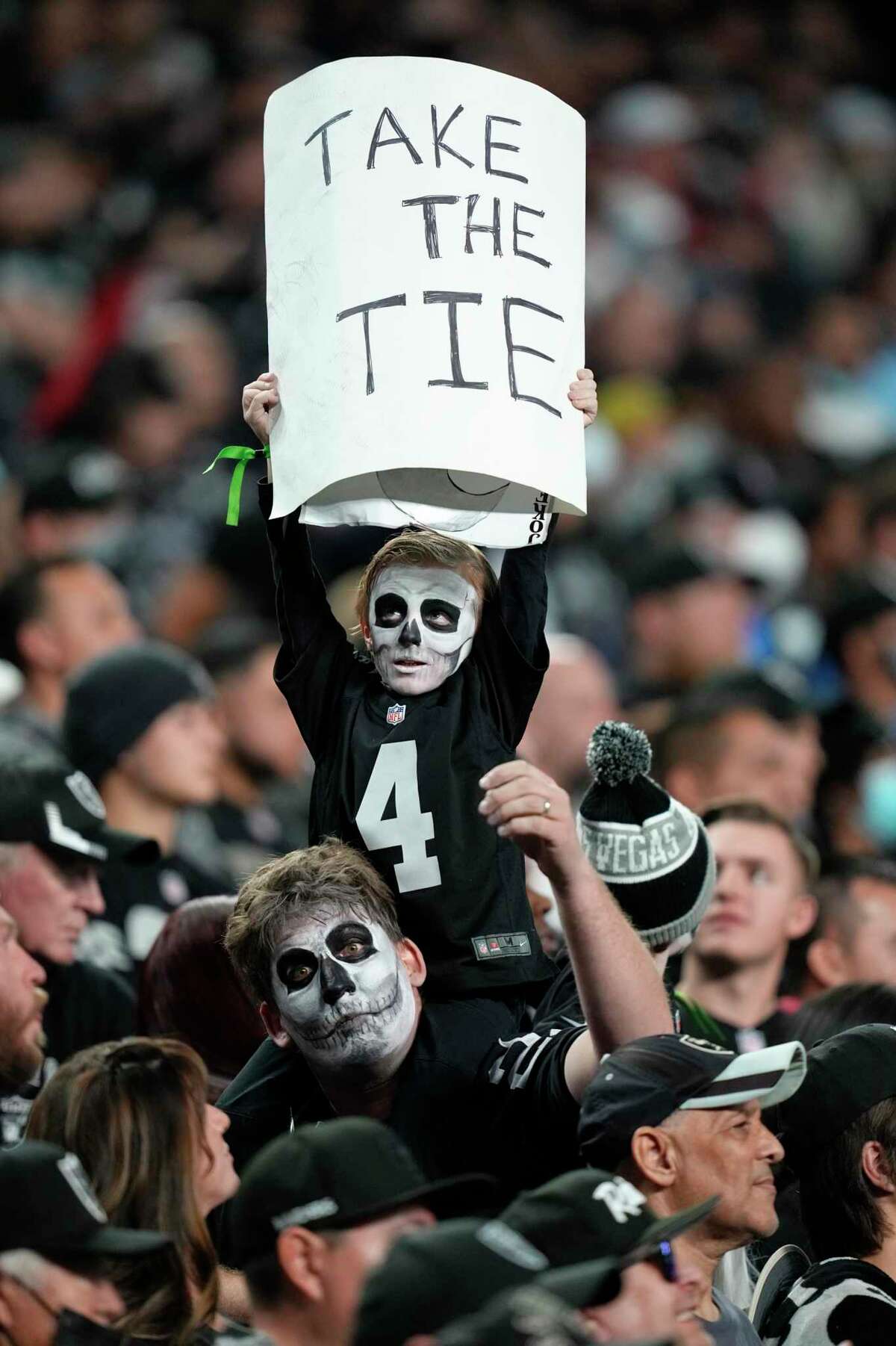 A young fan holds up a sign during overtime of an NFL football game between the Las Vegas Raiders and the Los Angeles Chargers, Sunday, Jan. 9, 2022, in Las Vegas. (AP Photo/Jeff Bottari)