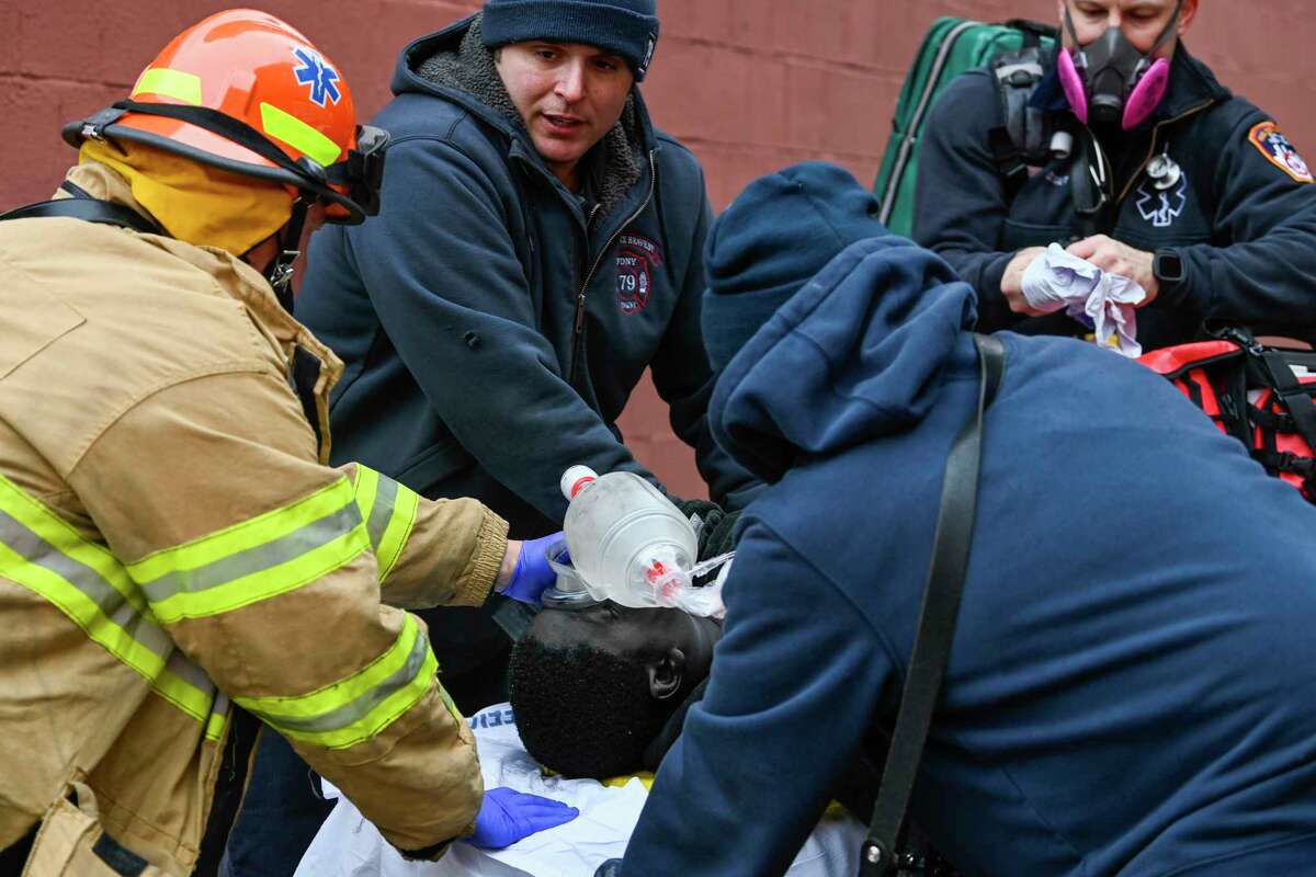 Emergency personnel perform CPR on a fire victim during a high rise fire on East 181 Street, Sunday, Jan. 9, 2022, in the Bronx borough of New York.