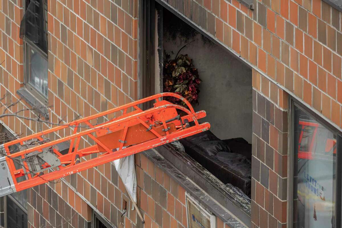 A ladder leads up to a window after a fatal fire at an apartment building in the Bronx on Sunday, Jan. 9, 2022, in New York. The majority of victims were suffering from severe smoke inhalation, FDNY Commissioner Daniel Nigro said.