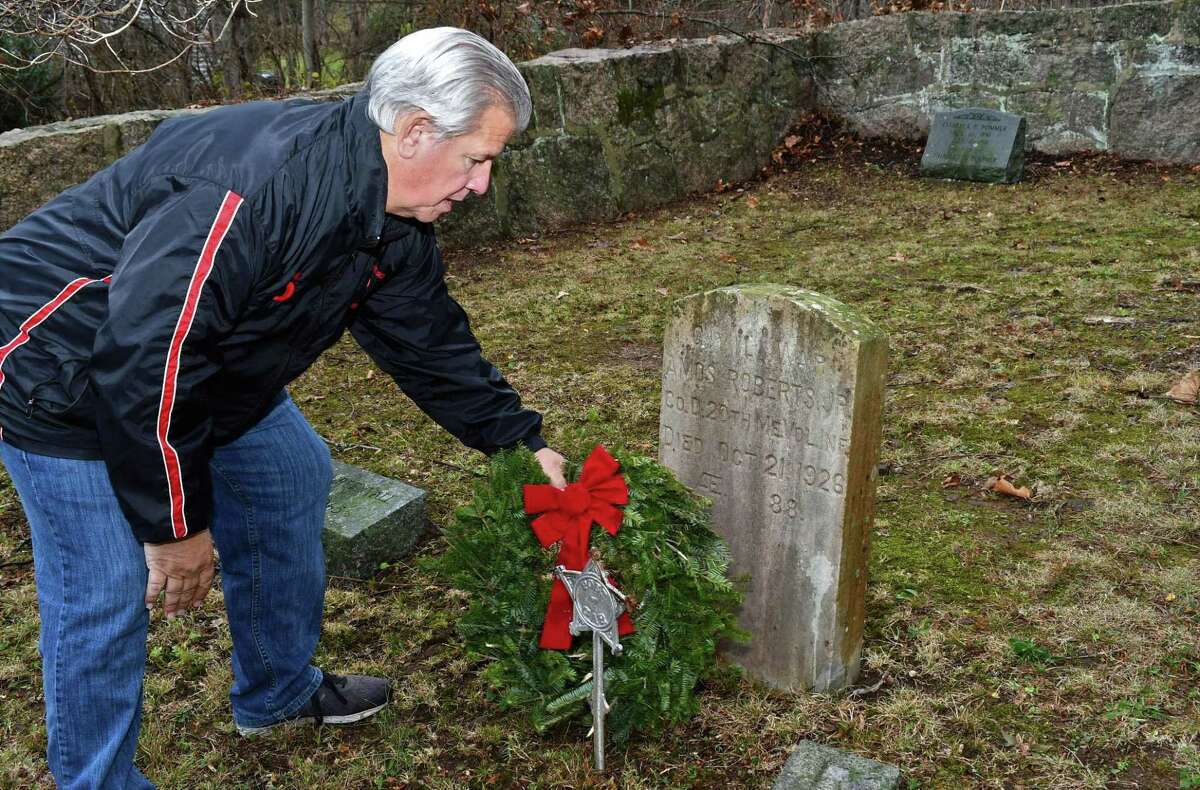 Branford Recreation Director Alex Palluzzi places a wreath on the grave of a Civil War vet at Branford's oldest cemetery Damascus Cemetery when some 500 wreaths were places on veteran’s graves in Branford.