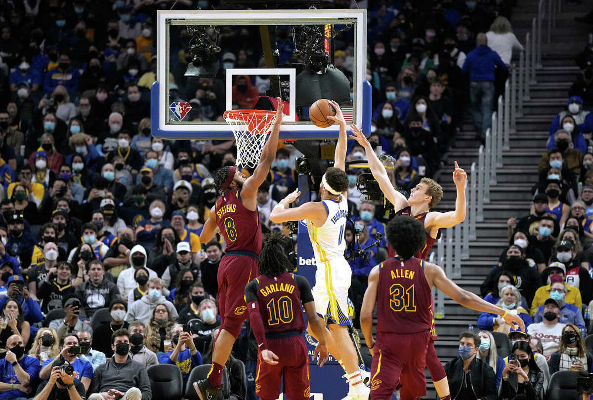 Klay Thompson of the Golden State Warriors slam dunks over Lamar Stevens of the Cleveland Cavaliers during the second quarter at Chase Center on Jan. 9, 2022, in San Francisco.