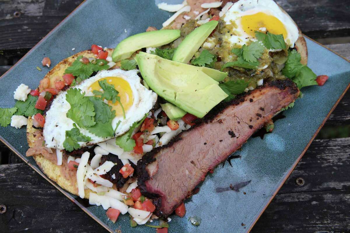 A plate of 2 servings of brisket huevos rancheros, which is a great way to use your leftover brisket. This photo has an extra slice of brisket.