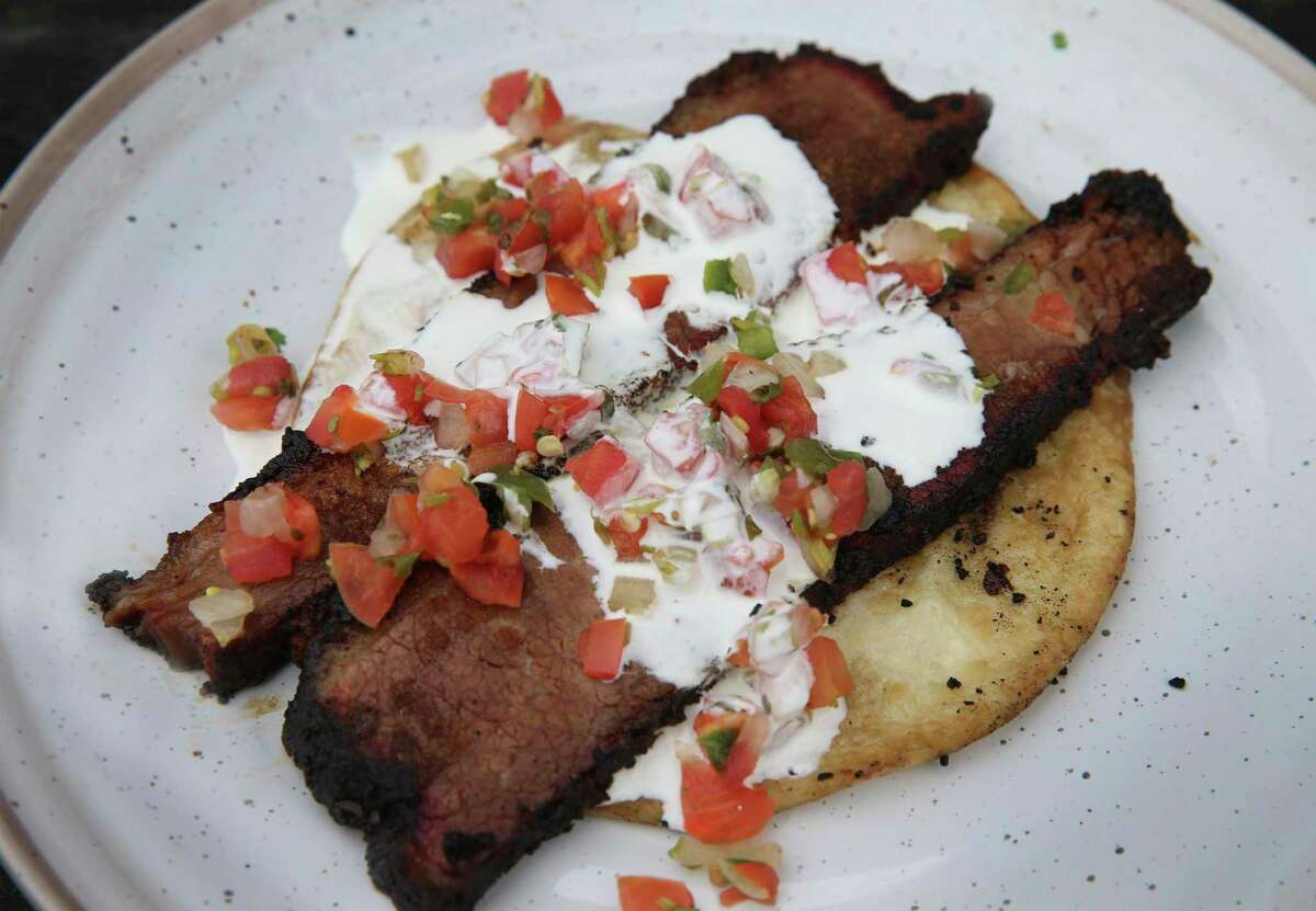 A brisket taco made with leftover meat is a quick breakfast on a tortilla with pico de gallo and sour cream.