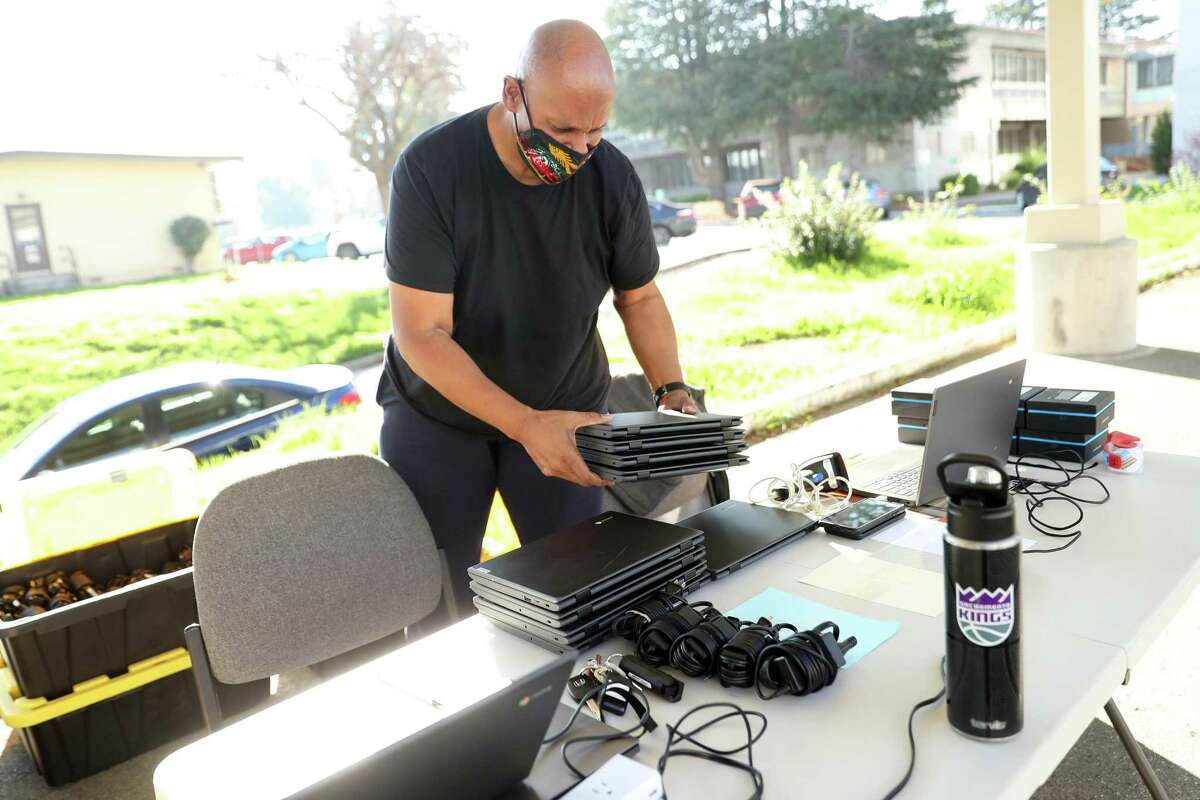 Preparing for the return to remote learning, Huie Dinwiddie readies Chromebooks for distribution at Hayward Unified School District headquarters.