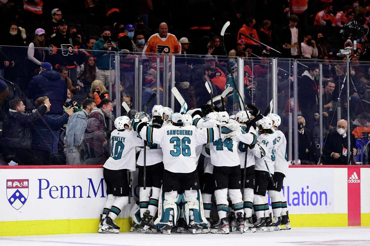 The San Jose Sharks celebrate an overtime victory after a goal scored by Tomas Hertl during an NHL hockey game against the Philadelphia Flyers, Saturday, Jan. 8, 2022, in Philadelphia. (AP Photo/Derik Hamilton)