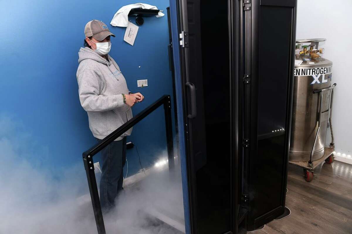 Allyson Tanner is photographed by a cryotherapy chamber at KUR Cryotherapy & Recovery Spa on Main Street in Old Saybrook on January 6, 2022. Tanner owns the spa with her husband, Jeff.