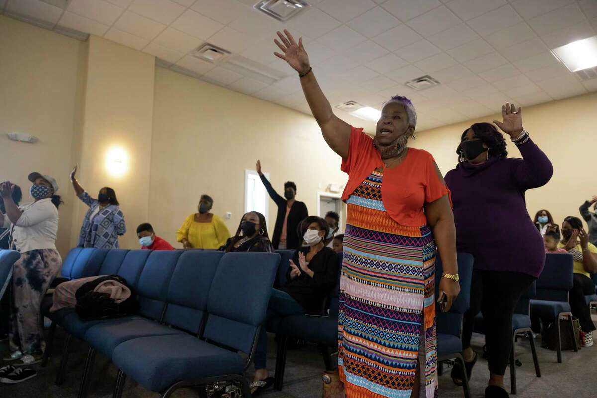 Congregants partake in a prayer during a church dedication ceremony at HopeWell Community Church, March 9, 2021, in Conroe. Police are investigating a shooting that reportedly caused damage to the church.