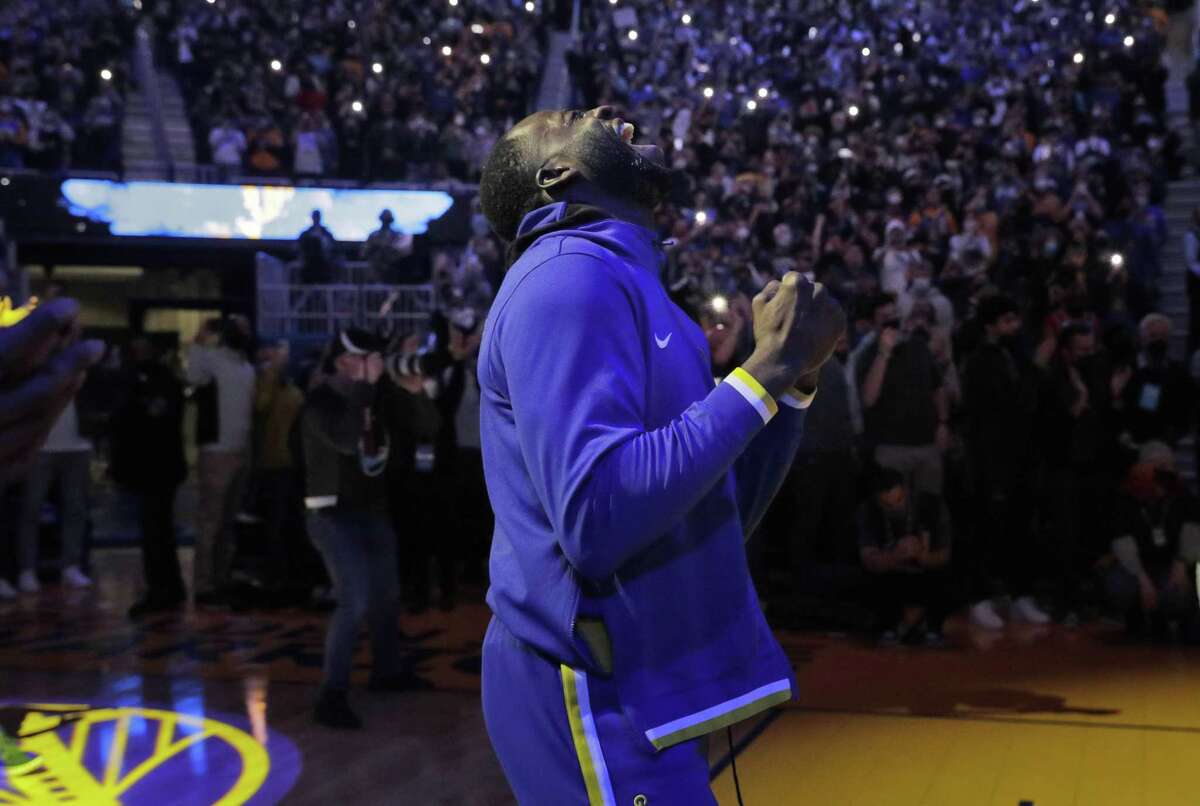 Draymond Green (23) reacts to Klay Thompson (11) being introduced In the first half as the Golden State Warriors played the Cleveland Cavaliers at Chase Center in San Francisco, Calif., on Sunday, January 9, 2022. Thompson returns to the court for the first time after injuries sidelined him for more than 900 days.