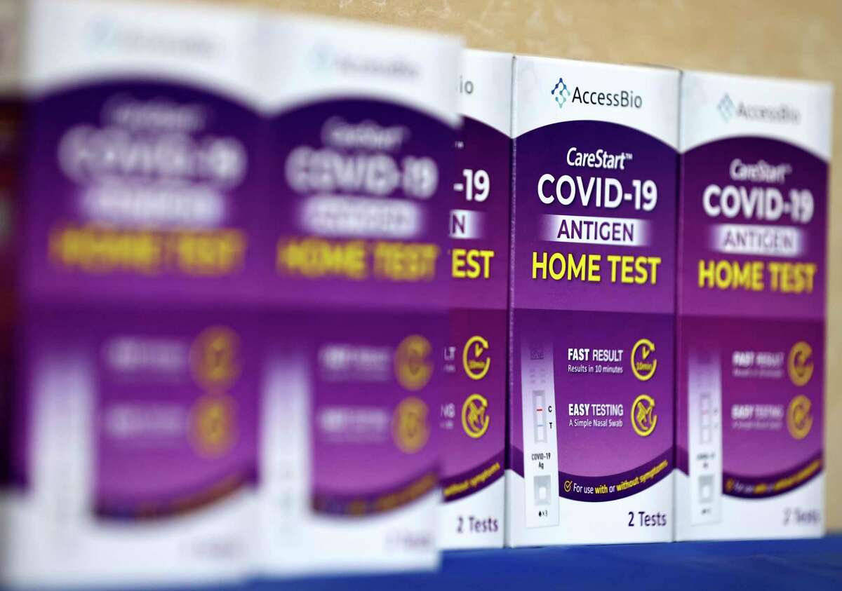COVID-19 rapid at-home test kits rest on a table at a free distribution event for those who received vaccination shots or booster shots Jan. 7 at Union Station in Los Angeles.