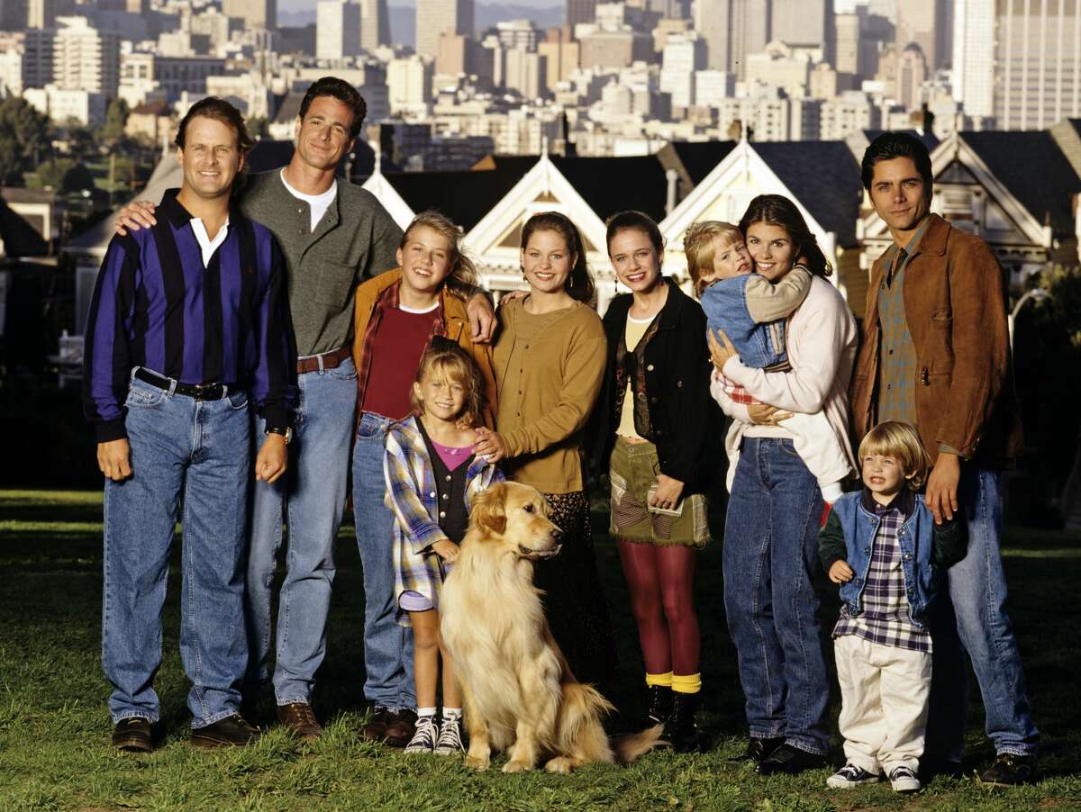The cast of "Full House" stands in front of the Painted Ladies on Sept. 27, 1994. Pictured, from left: Dave Coulier (Joey), Bob Saget (Danny), Jodie Sweetin (Stephanie), Mary Kate Olsen (Michelle), Candace Cameron (D.J.), Andrea Barber (Kimmy), Blake Tuomy-Wilhoit (Nicky), Lori Loughlin (Rebecca), Dylan Tuomy-Wilhoit (Alex), John Stamos (Jesse). 