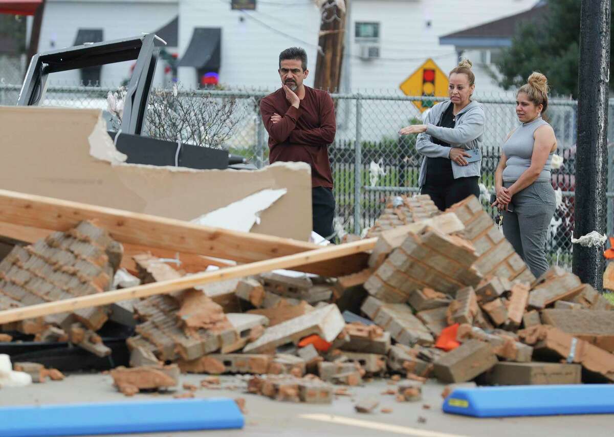 People survey damage to a business complex after a tornado ripped through the area, Sunday, Jan. 9, 2022, in Humble.