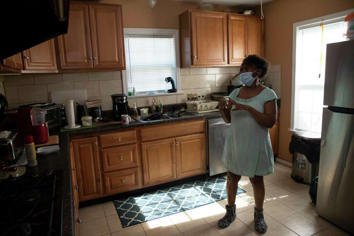 Betty Gregory shows the kitchen cabinets that were redone by her husband after their house was damaged by Hurricane Harvey Monday, Jan. 10, 2022, in Kashmere Gardens in Houston. Weldon Gregory, who died about six months ago, was a carpenter and fixed up a lot of the house himself with financial help from Betty’s sons, but the city said it was still in such bad shape it needed to be torn down.