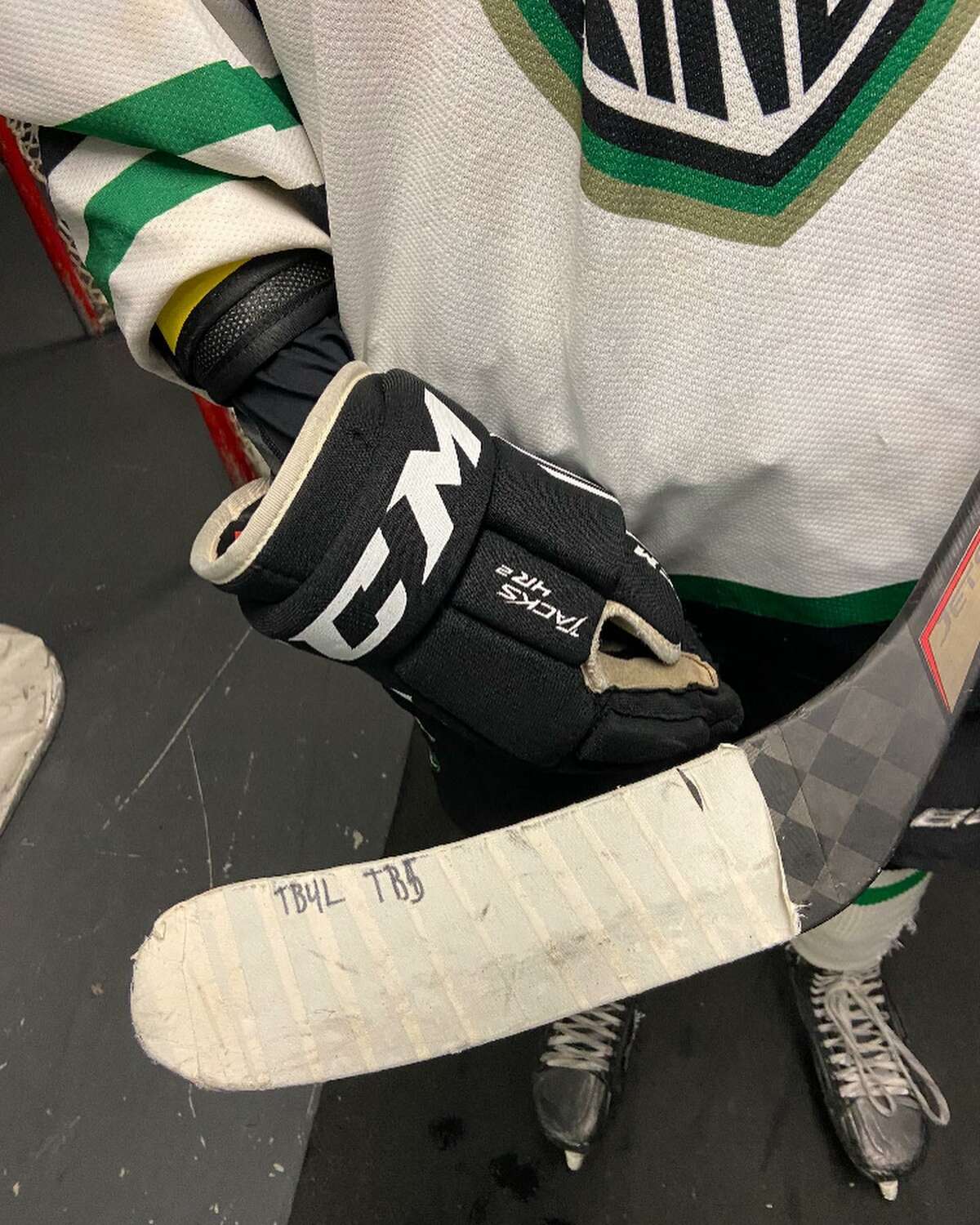 Sam Brande, who started a petition in the wake of the death of his friend Teddy Balkind, shows off his stick that includes Balkind’s initials. Brande’s petition calls for a requirement, not a recommendation of neck guards in hockey.