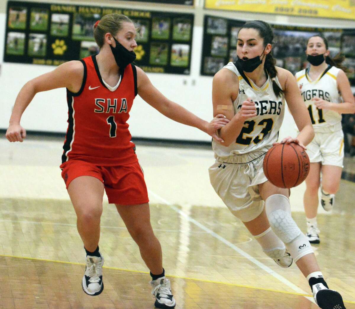 Hand’s Sophia Coppola droves to the basket as Emma Kirck of Sacred Heart Academy defends during the Tigers’ 39-36 win Monday night.