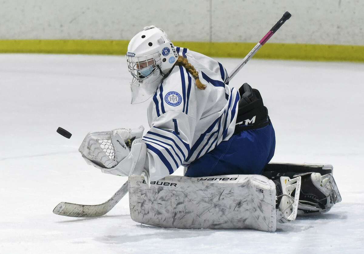 Darien goalie Claire Haupt makes a glove save against New Canaan during a girls ice hockey game at the Darien Ice House on Monday Jan. 10, 2022.