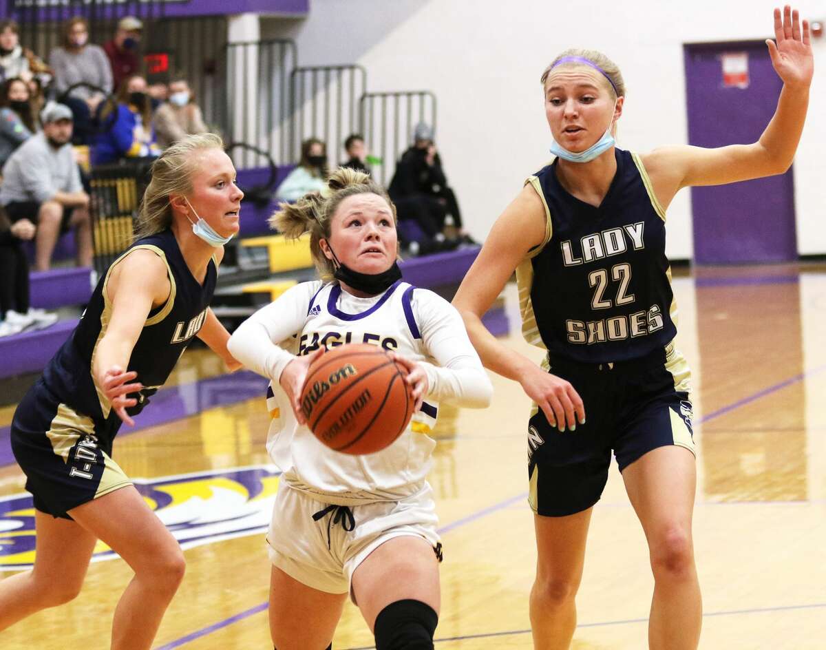 CM's 5-3 Aubree Wallace splits a pair of 6-foot Wooden Shoes in Kaitlyn Schumacher (left) and Emily Konkel (22) on a drive to the basket Monday night in Bethalto.
