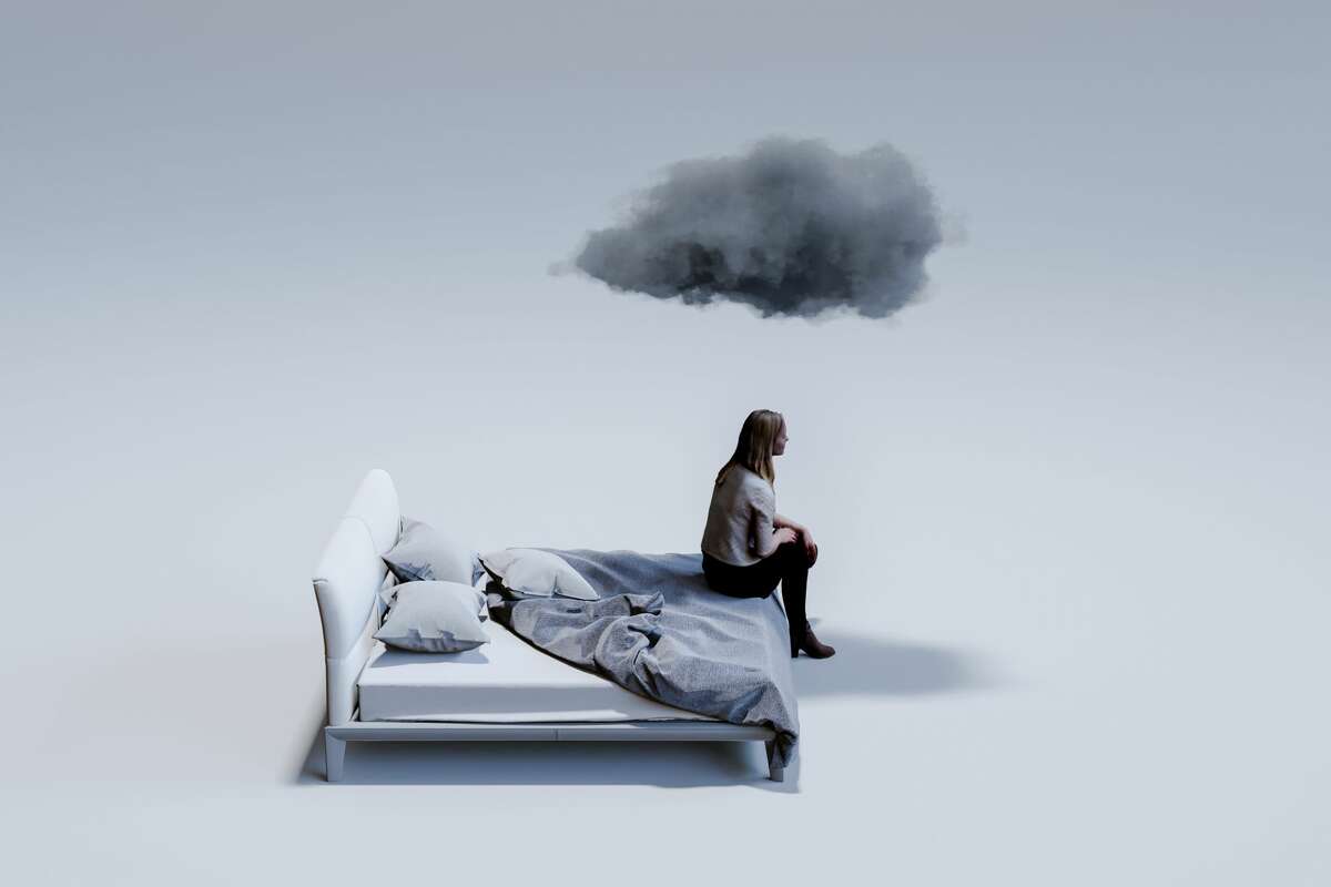 Computer graphic of a woman sitting on corner of double bed with dark cloud above head. 