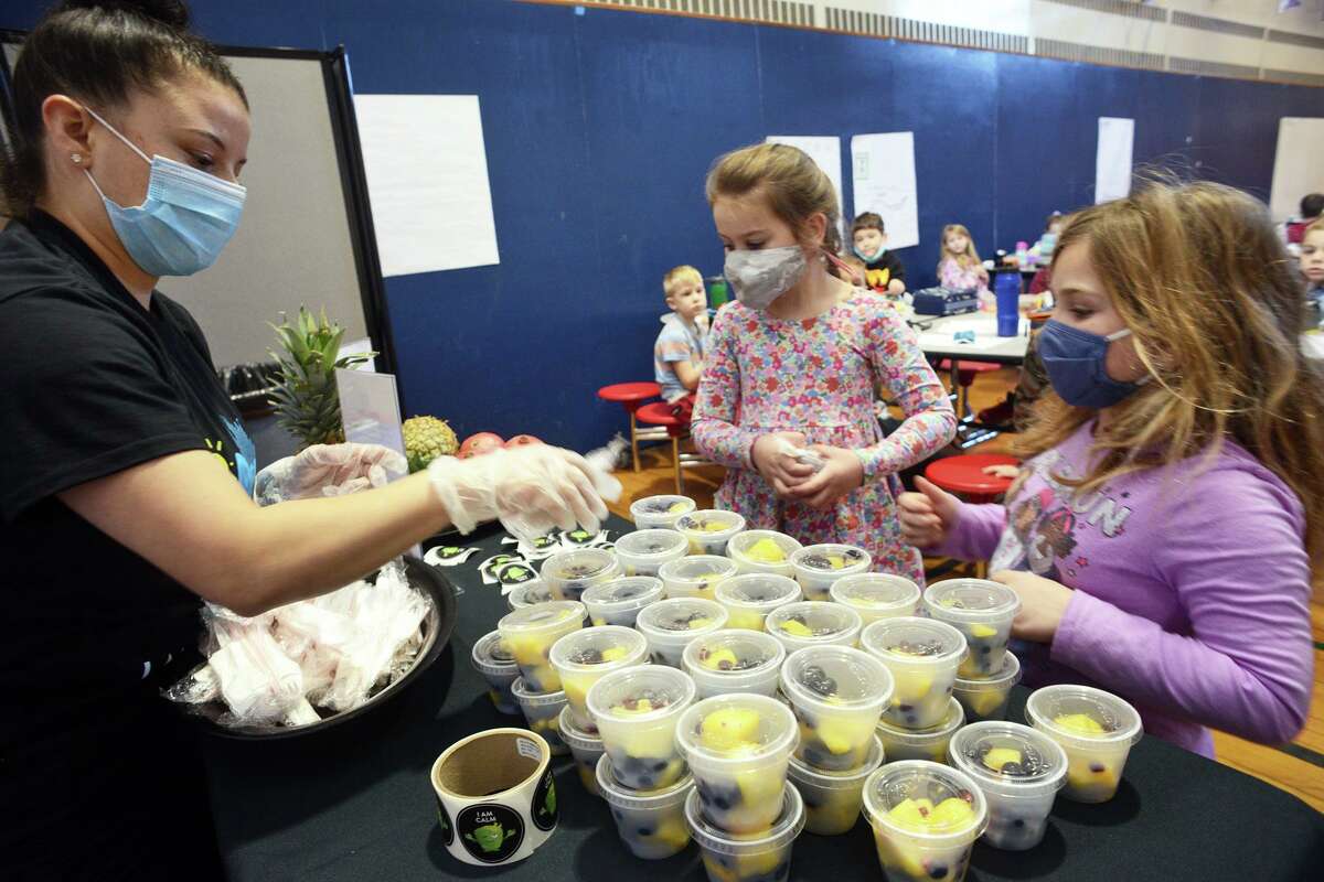 Angela Valentin of Chartwells serves students Mood Boost “smart fruit salads” during lunch at Cranberry Elementary School, in Norwalk, Conn. Jan. 11, 2022.