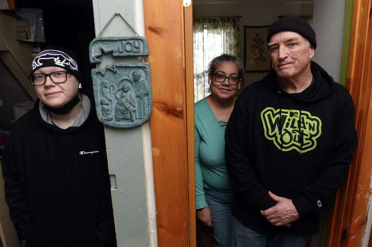Mark Colville, right, at his home in New Haven with his wife, Luz Catarineau, center, and their son Isaiah, 19, on Jan. 11, 2022.