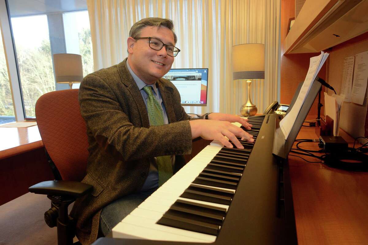 Frank Martignetti plays piano in his office on the West Campus of Sacred Heart University, in Fairfield, Conn. Jan. 11, 2022. Martignetti is director of SHU’s music education program.