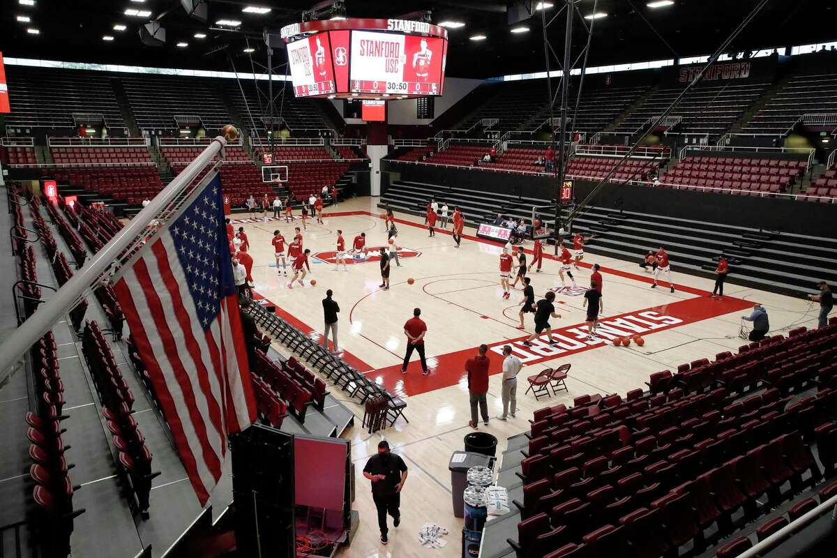 A few Stanford guests watch in warm ups in an empty arena before game an NCAA college basketball game against Southern California, Tuesday, Jan. 11, 2022, in Stanford, Calif. (AP Photo/Josie Lepe)