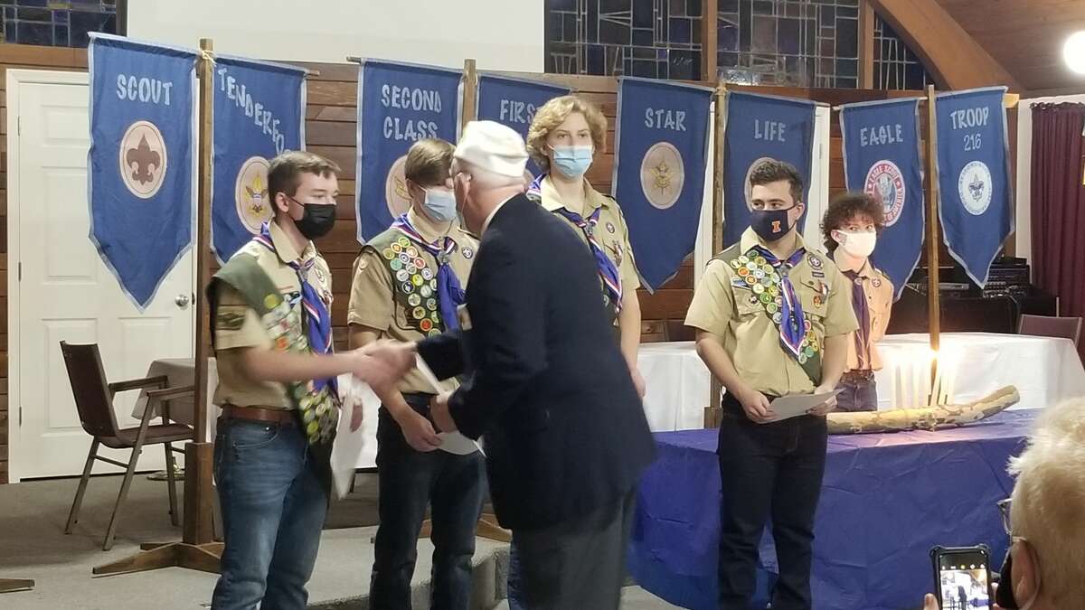 Larry Miller of the American Legion presenting certificates to each of the Eagle Scouts and congratulating them during Monday's ceremony. 