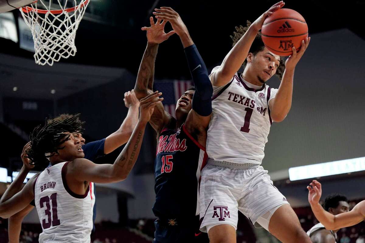 Texas A&M guard Marcus Williams (1) grabs a rebound away from Mississippi forward Luis Rodriguez (15) during the first half of an NCAA college basketball game Tuesday, Jan. 11, 2022, in College Station, Texas. (AP Photo/Sam Craft)